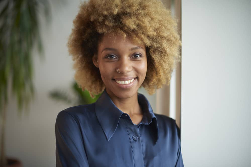 African American female with natural black hair that's been bleached creating a blonde hair shade.