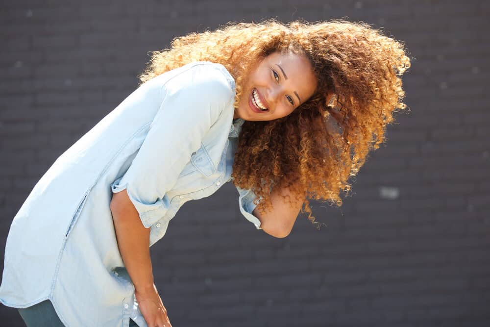 Black girl laughing after using Color Oops hair color remover to regain her natural color