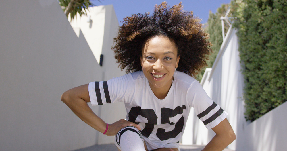 Cute African American female with a black natural hair color that's been dyed on the tips with brown hair dye.