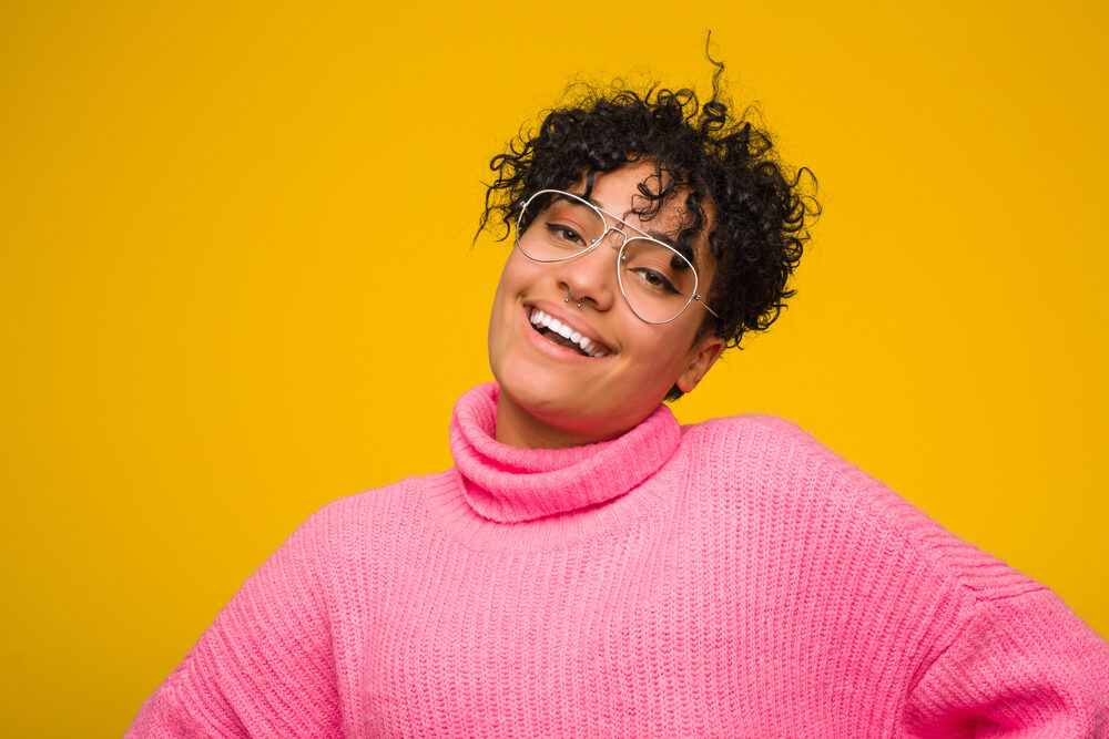 A cute African American woman wearing black Ion hair dye to enhance her natural color.