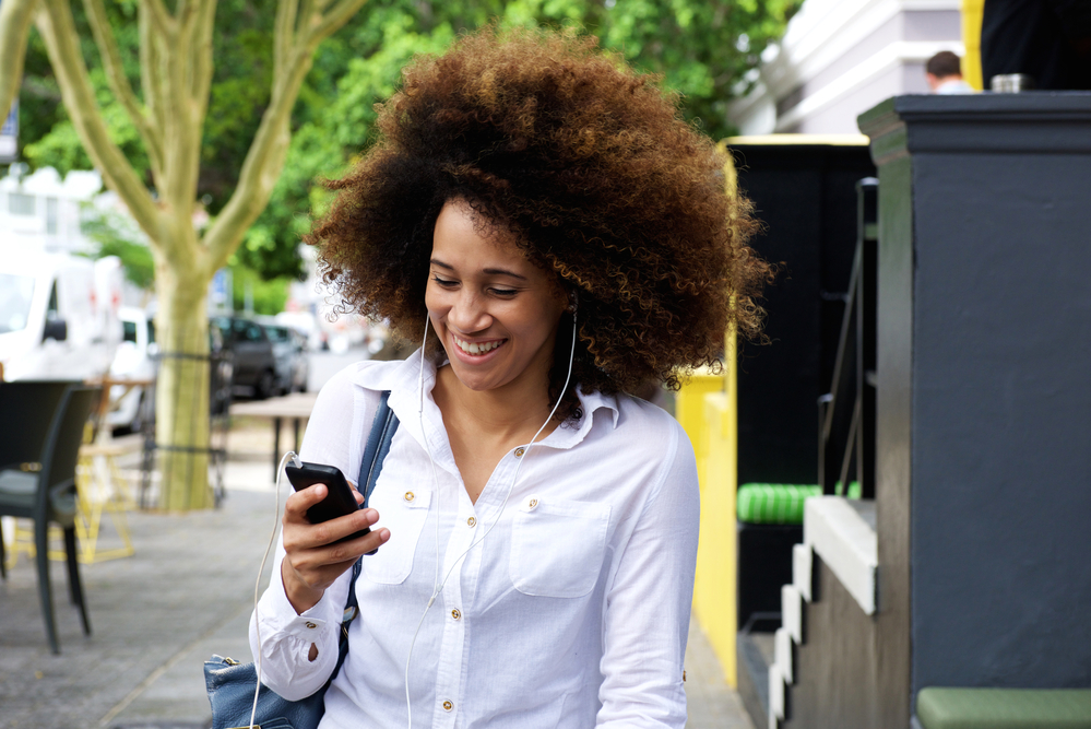 Black lady leaving Sally's Beauty Supply after shopping for vibrant color brilliance semi-permanent hair dye.