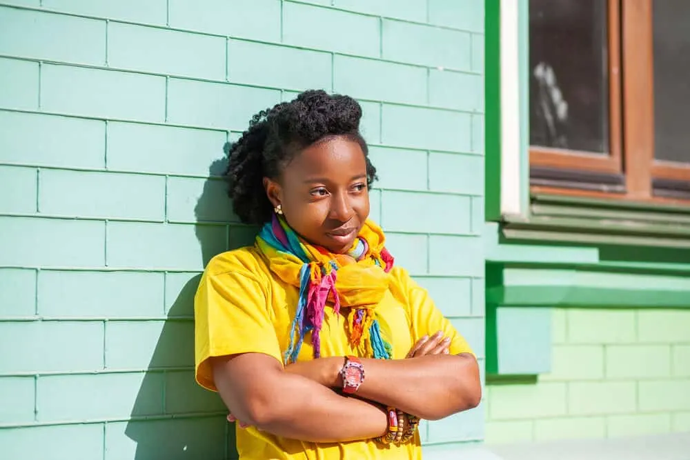 Can Your Hair Get Moldy? What Causes It? How To Get Rid of It? 6 Black lady wearing a curly hairstyle created with a hair dryer, wide-tooth comb, and leave-in conditioner.