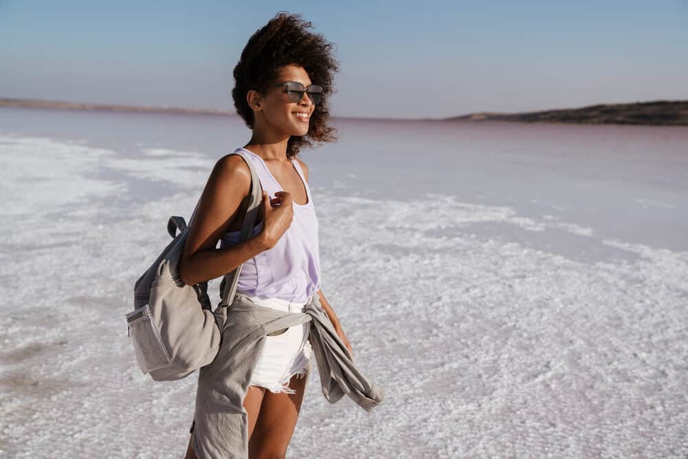 African woman with a big smile and bouncy healthy hair that's styled with natural oils.