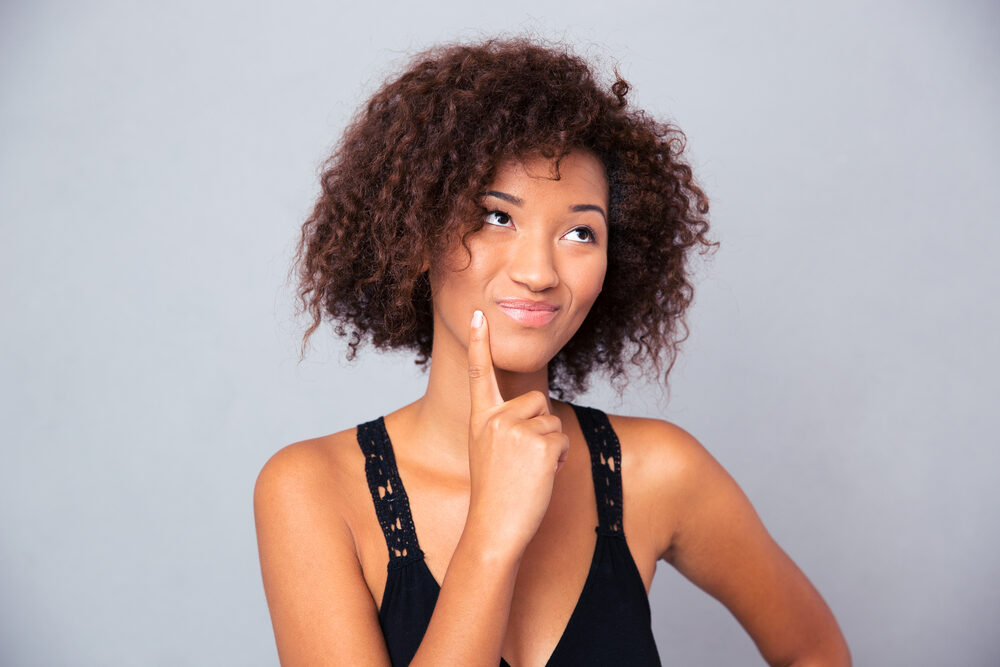 Black girl with curly dry hair that hasn't done a good job moisturizing her curls.