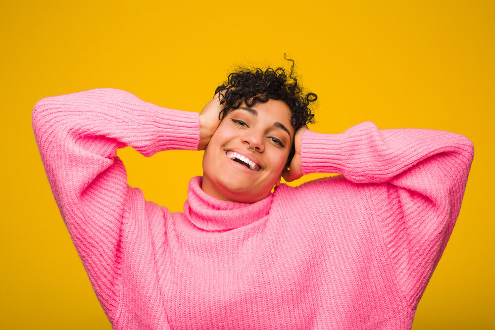 A woman wearing a pink sweater after using Ion Color Defense Shampoo to remove hair dye.