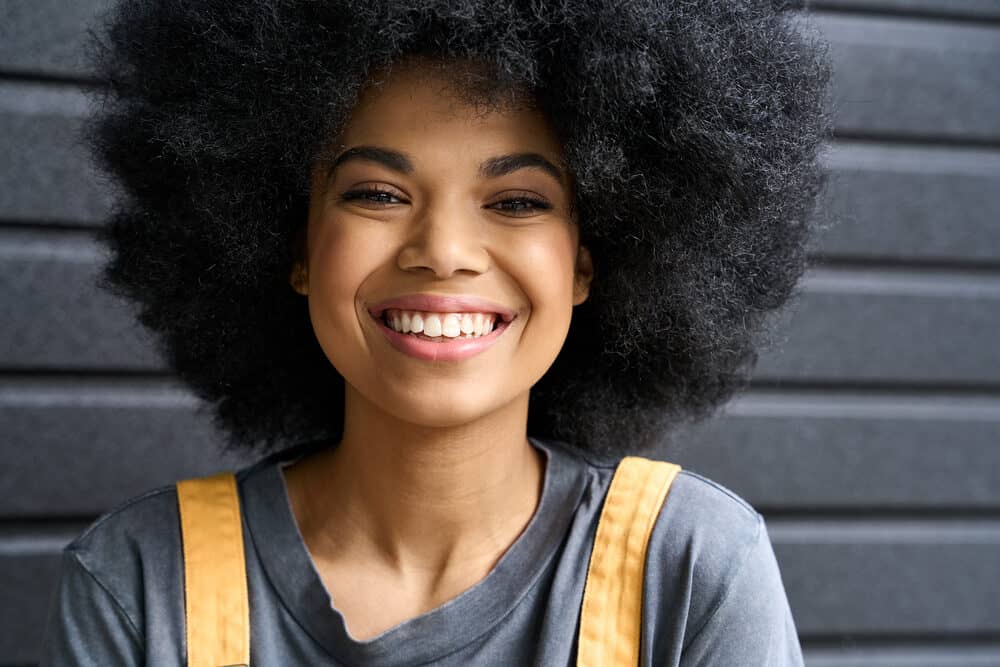 Beautiful African American female with curly healthy hair styled with avocado oil and aloe vera gel