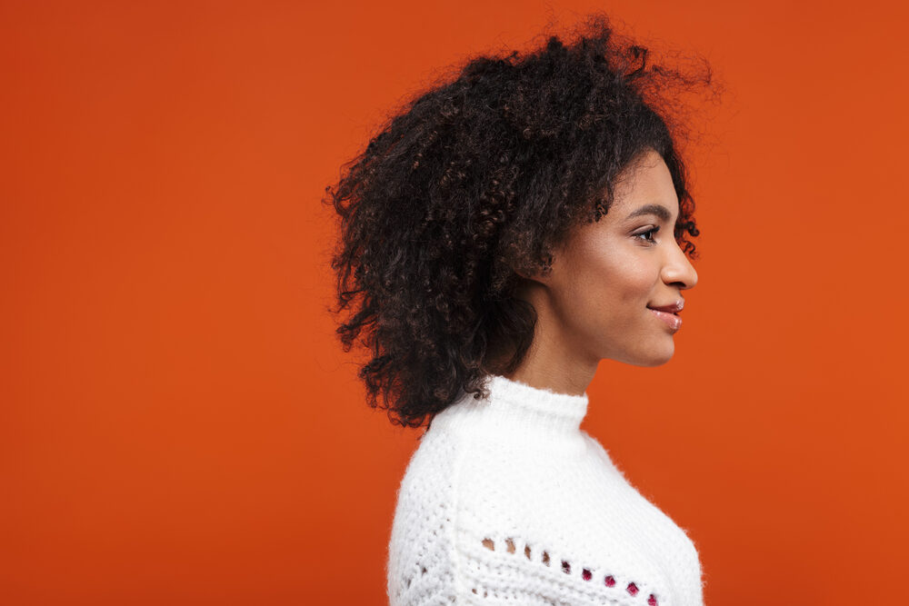 A beautiful black lady wearing a twist-out hairdo on naturally light-colored hair that's been dyed with coffee.