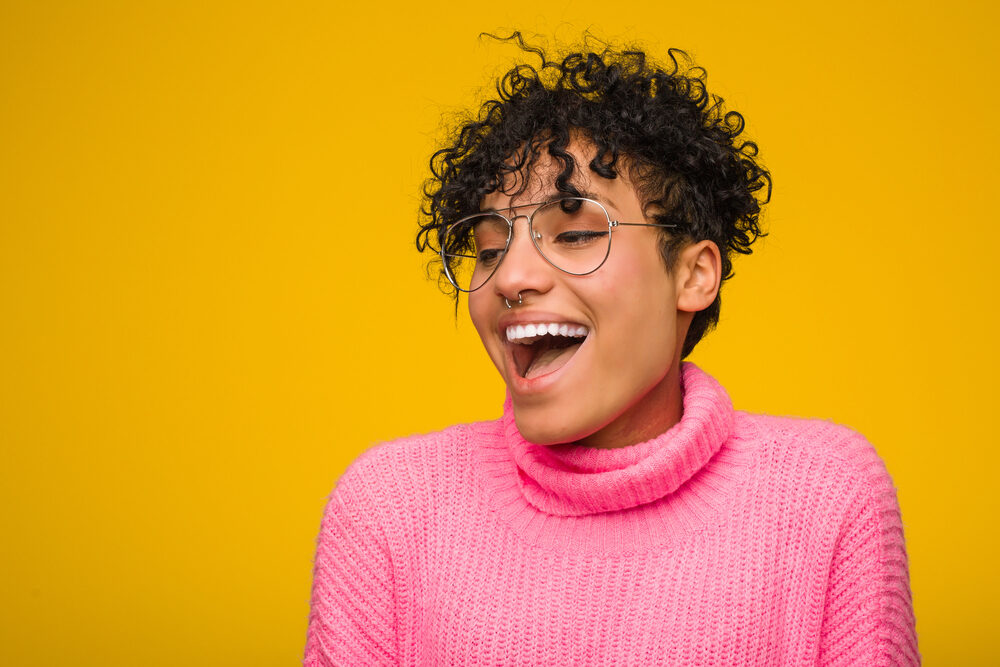 Pretty black girl with a big smile wearing medium brown permanent hair color (or permanent hair colour).