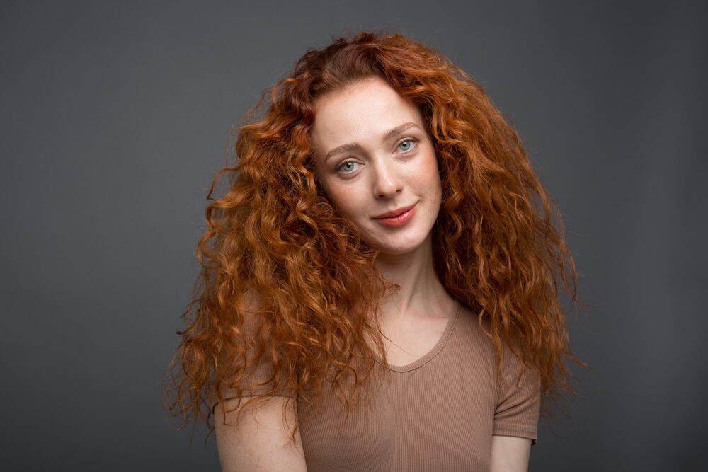 White woman with light brown hair dyed a lighter shade with Sun-In Hair Lightener.