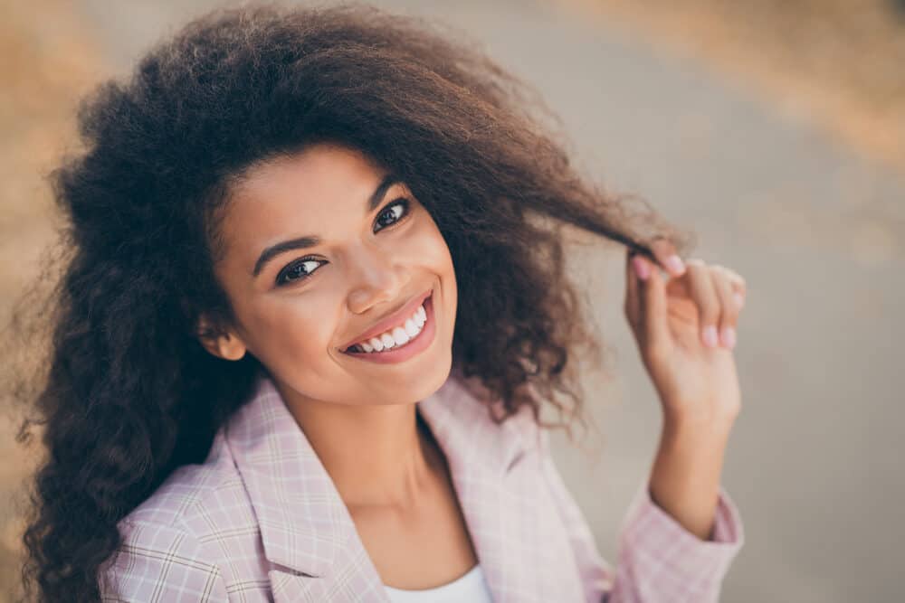 Cute light-skin black lady in a business suit with oily hair styled with Herbal Essences salon products.