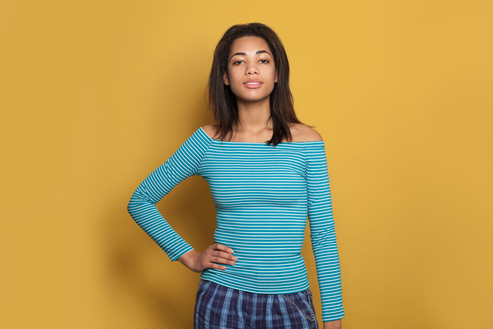 Beautiful dark-skinned girl with curly hair underneath her straighter hair on top.