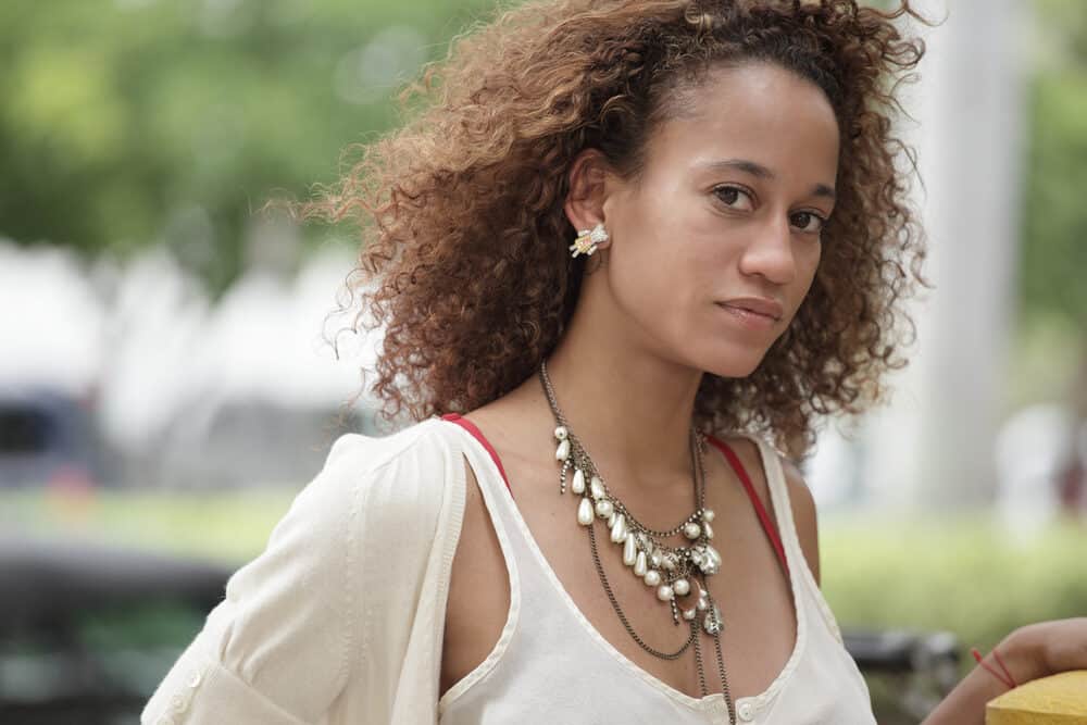 African American female with a dark brown hair color with brassy tones and an unwanted tint.