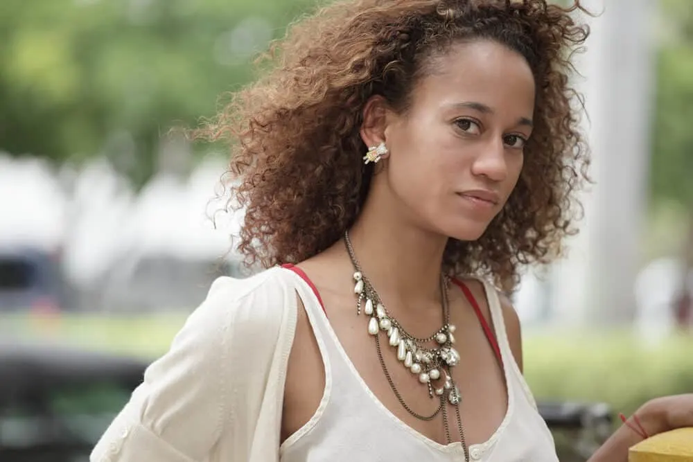 Leaving Purple Shampoo in Your Hair for an Hour or More? What Happens? 1 African American female with a dark brown hair color with brassy tones and an unwanted tint.