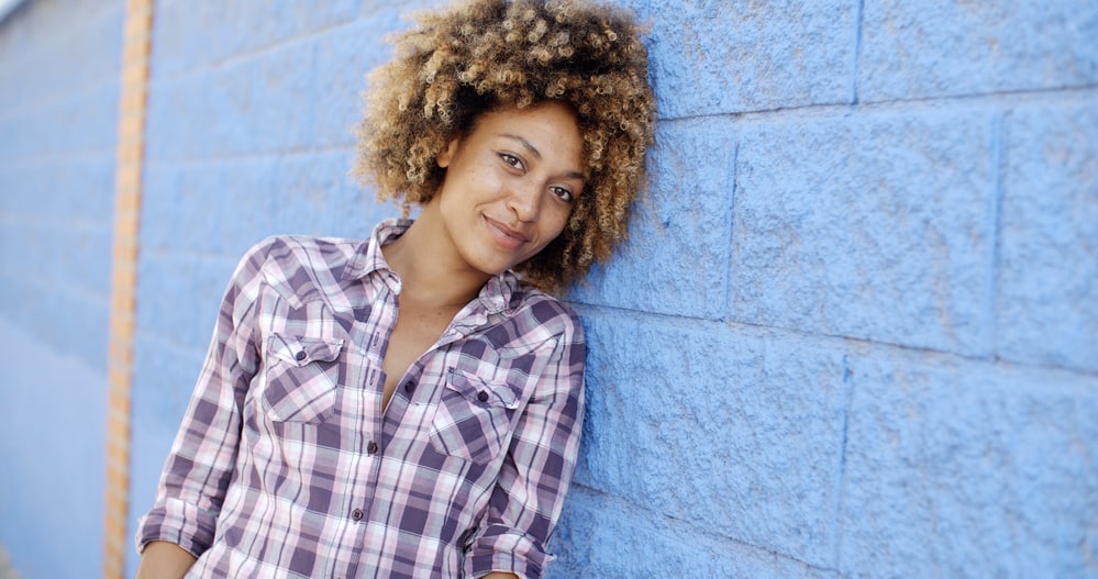 African American female wearing a wash n go hairstyle with light brown tips.