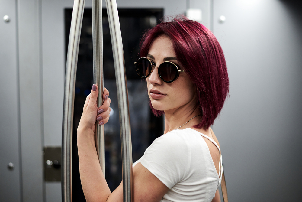 Young woman with a pale white skin tone wearing type 1A that's been dyed reddish-purple.