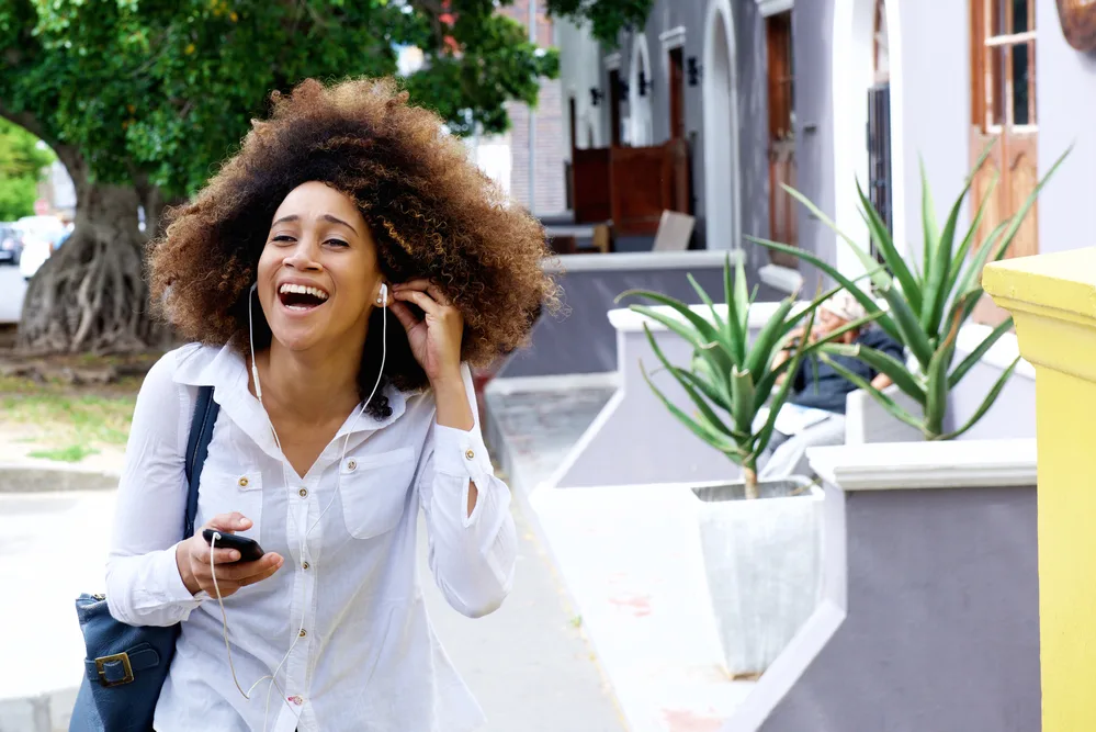 How To Use Ion Semi-Permanent Hair Color: Step-by-Step Tutorial 10 Young black woman with ultra-rich super thick hair on the phone laughing.