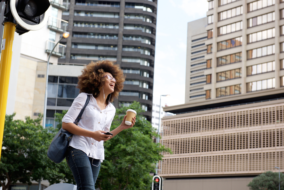 A woman with natural brown hair dyed with blonde semi-permanent hair color walking in New York City.