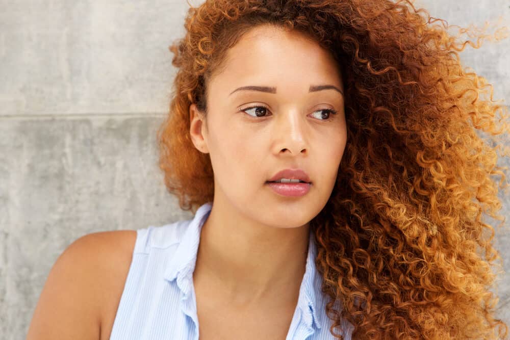 Beautiful young woman with natural black hair that's been bleached and dyed a red color