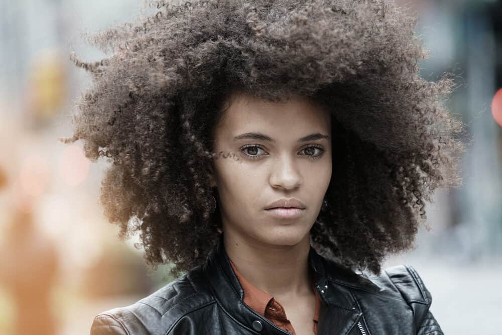 Mixed-raced lady with medium brown hair wearing a black leather jacket