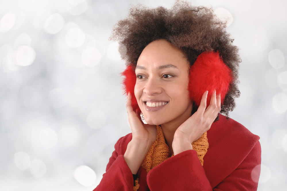 A smiling young woman with earmuffs.