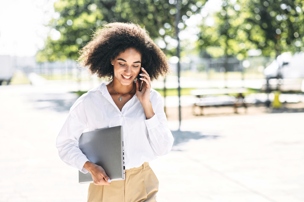 Why Does My Hair Fall Out When I Wash It? How To Stop It? 6 African American woman talking on an iPhone about her hair falling out in the shower.