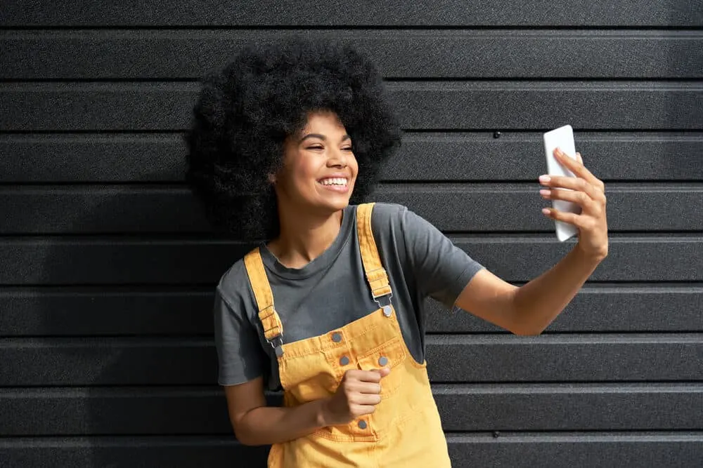 How to Moisturize Low Porosity Hair: DIY Step-by-Step Guide 8 Cute young African female with a big 4C curly hairstyle created with a hair steamer and thermal heat cap