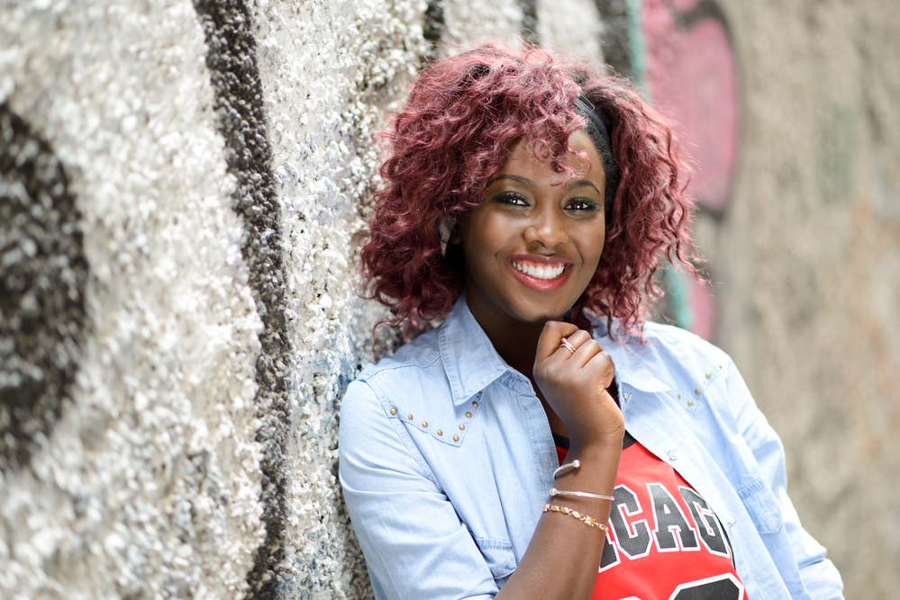 A cute lady after dying black hair red wearing a Chicago Bulls jersey.