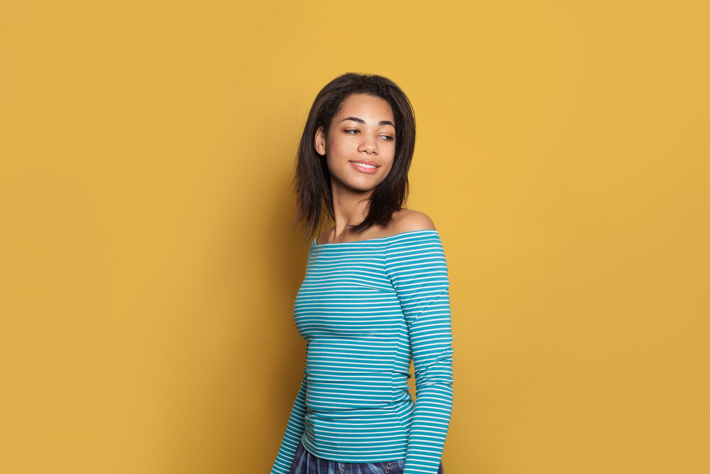 Pretty mixed race curly girl that has straightened her curls with a flat iron.