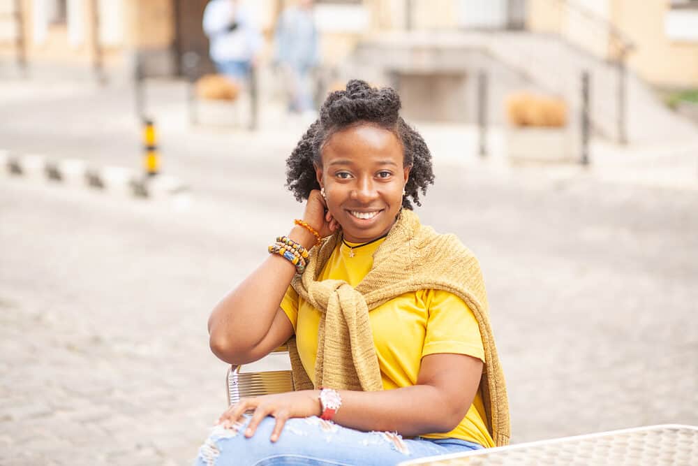 Cute black girl with flaky scalp wearing a curly updo with mini bantu knots on 4B hair.