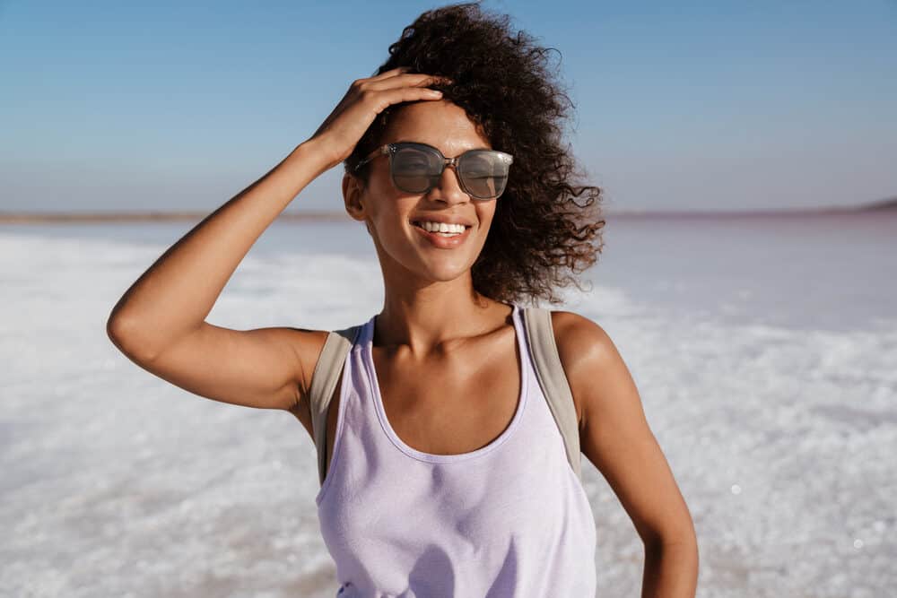 Attractive African female with long hair walking outside at Salt Lake during excessive heat.