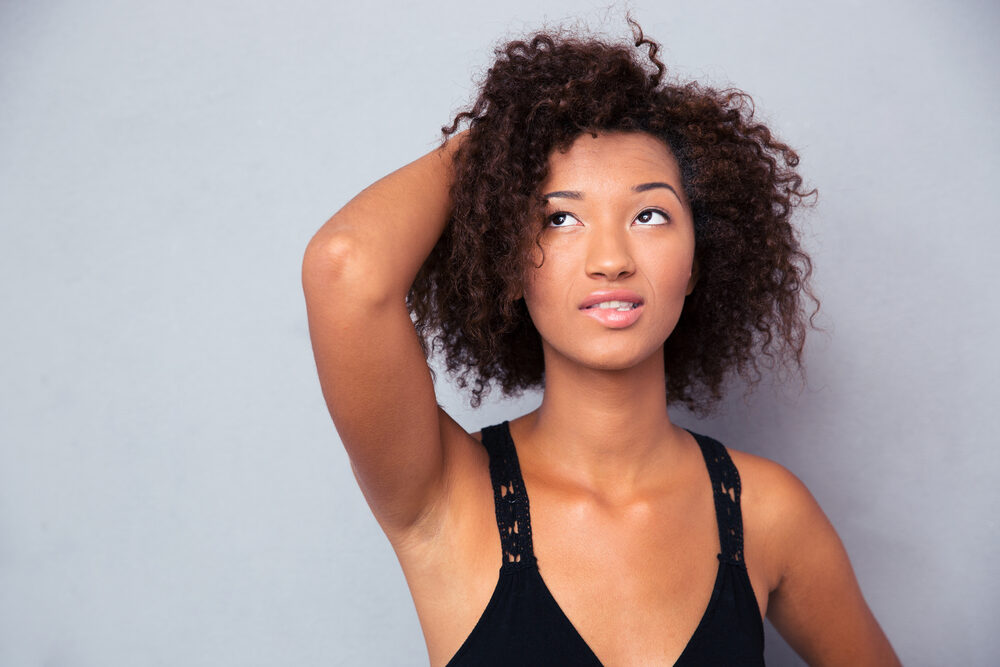 Cute African woman with fine hair styled with organic hair styling products.