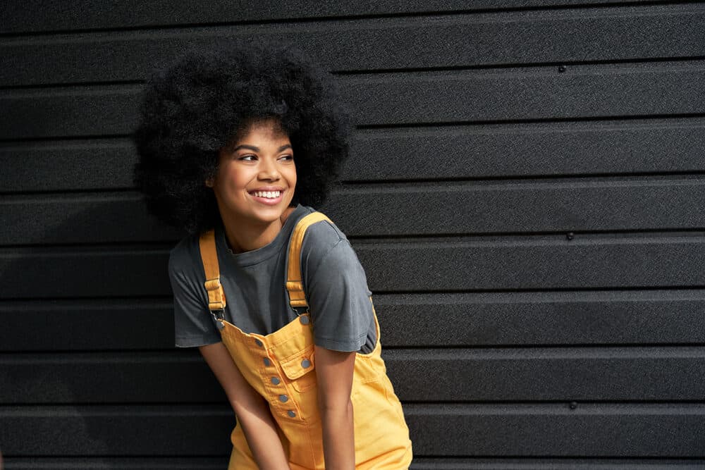 Stylish African American woman with curly hair cuticles in an afro styled with penetrating oils