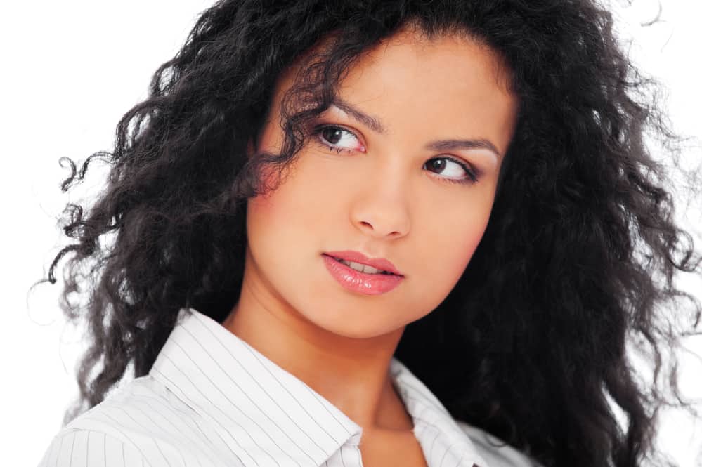 Cute woman with curly hair with smelly hair syndrome wearing pink lipstick and dress shirt