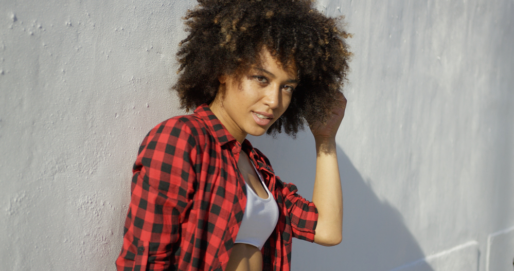 Beautiful girl with low porosity hair wearing a wash n go hairstyle and red and black checkered dress shirt.