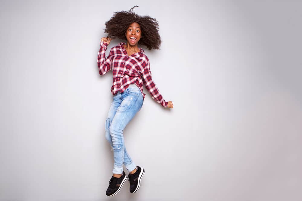 Excited young black woman celebrating after obtaining a barber license and during a certified cosmetology program.