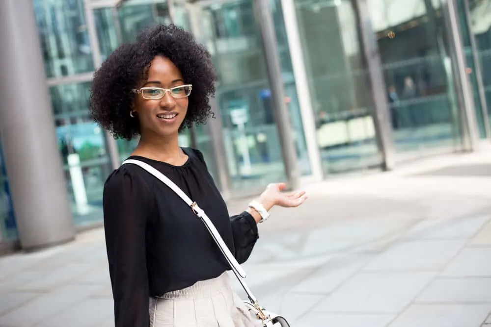 Hair Breakage on Top of Your Head: Causes, Fixes, Products, and More 1 Young African American lady with healthy hair wearing a curly twist-out hair style on a 4B hair type.