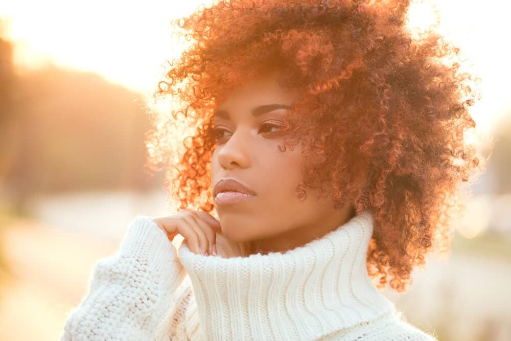 Beautiful African American girl with naturally dark brown hair colored with red hair dye.