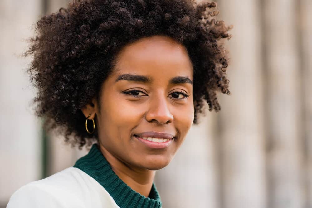 Cute lady with an afro styled with oils and fatty acids from the castor plant.