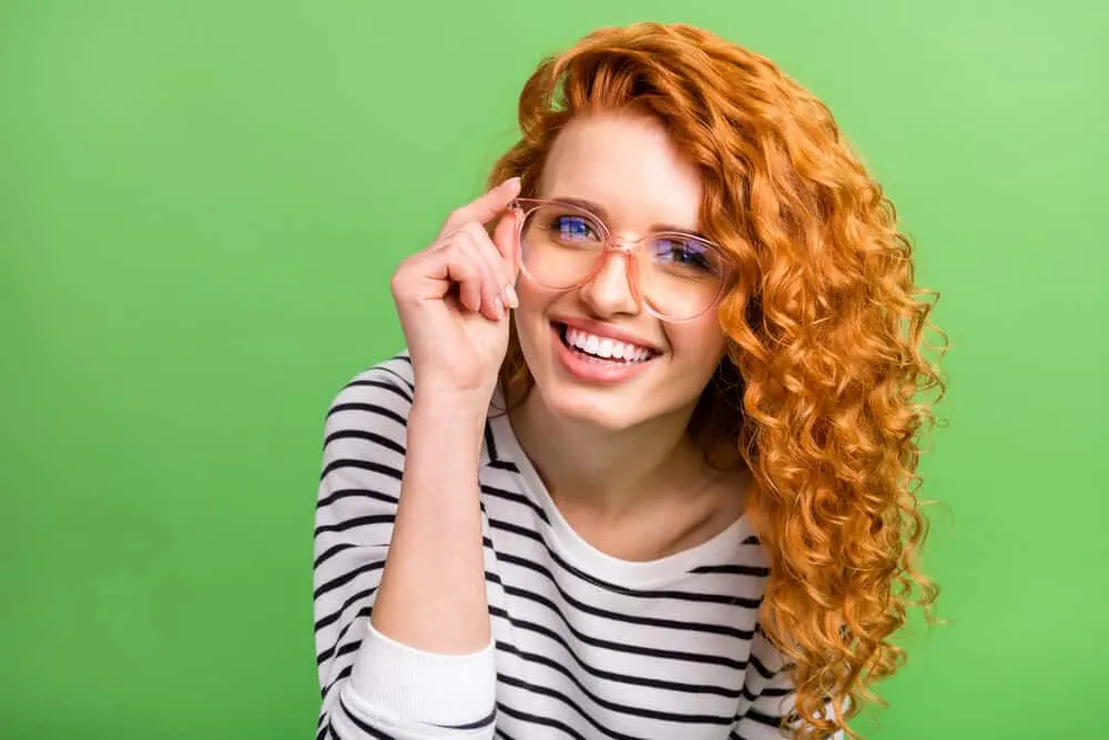 6 Rare Hair Colors: What Is the Rarest Hair Color in the World? 2 Cute white girl with darker hair trying a new pair of rose-colored glasses.
