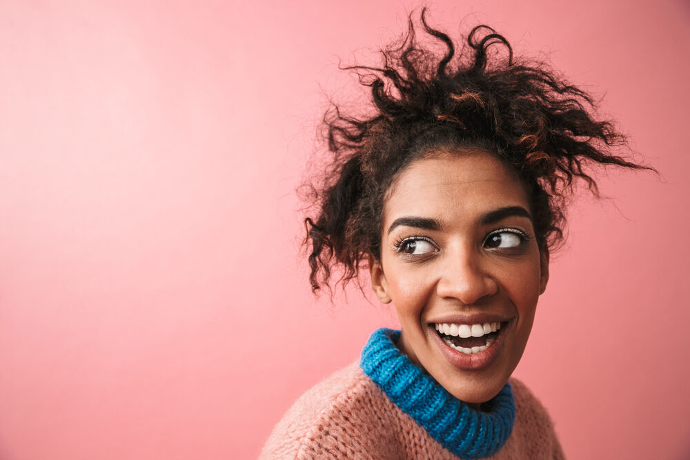 Cute African American female with fine hair that's been damaged hoping to repair hair with an Olaplex treatment.