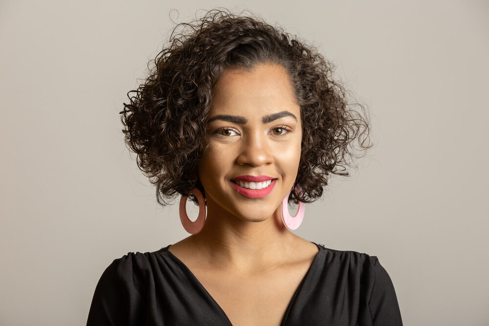 Cute black girl with a great smile wearing natural curls styled with a hair rinse from the "miracle tree".