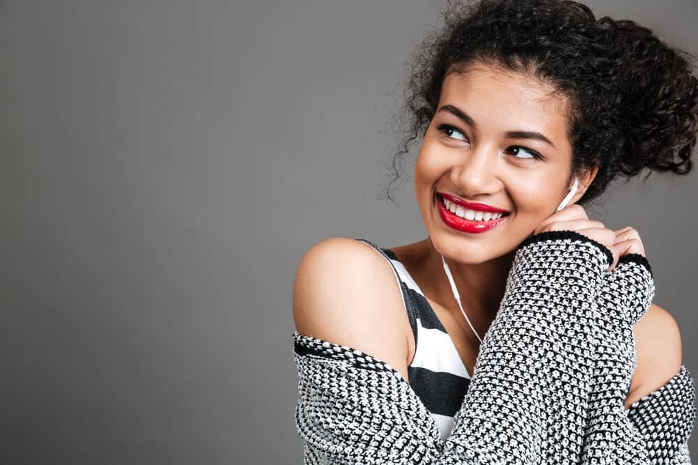 Cute light-skinned black girl with curly hair follicles styled with raw aloe vera juice to promote hair growth.