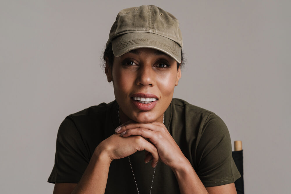 A black female soldier in uniform with naturally curly long hair wearing a ponytail that aligns with grooming standards.