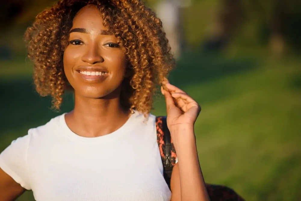 How Long to Leave Hair Dye In: Semi-Permanent and Permanent 5 Cute black girl with medium hair thickness and shoulder hair length wearing a curly twist-out hairdo.