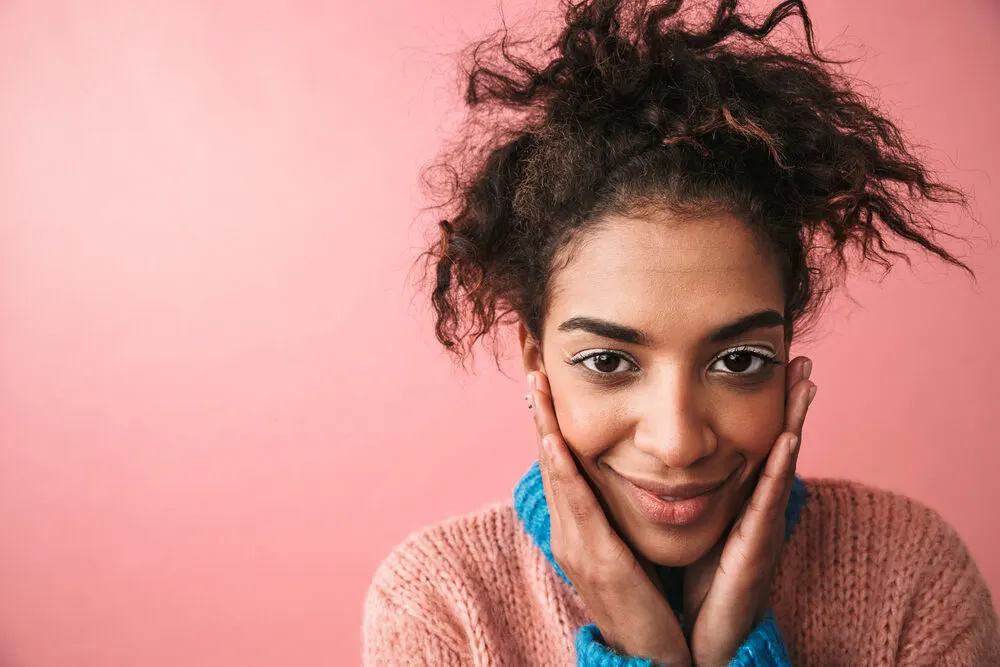 Is Olaplex Bad for Your Hair? Which Products? 3? 6? Shampoo? 15 Happy young black girl with a great smile and poor hair health using Olaplex treatments to prevent further damage.