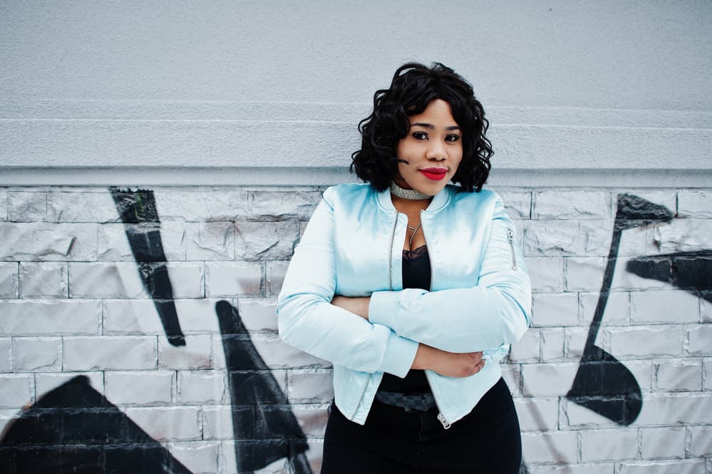 Stylish African American woman with an oval face shape and short hair length wearing a blue jacket.