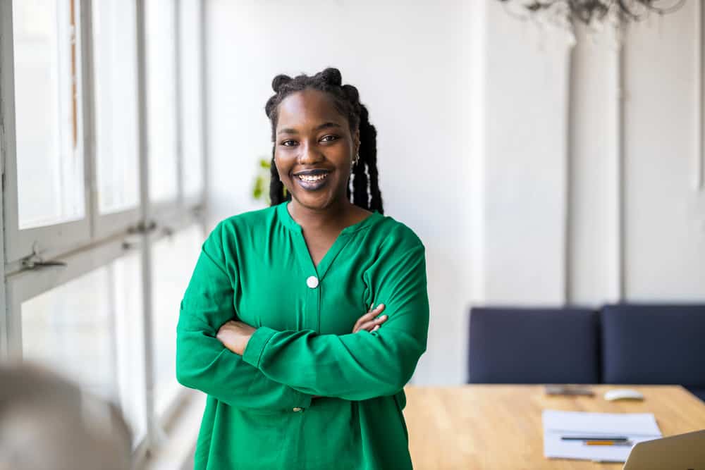 African American female with healthy dreads styled with hair accessories and natural oils wearing a green shirt.