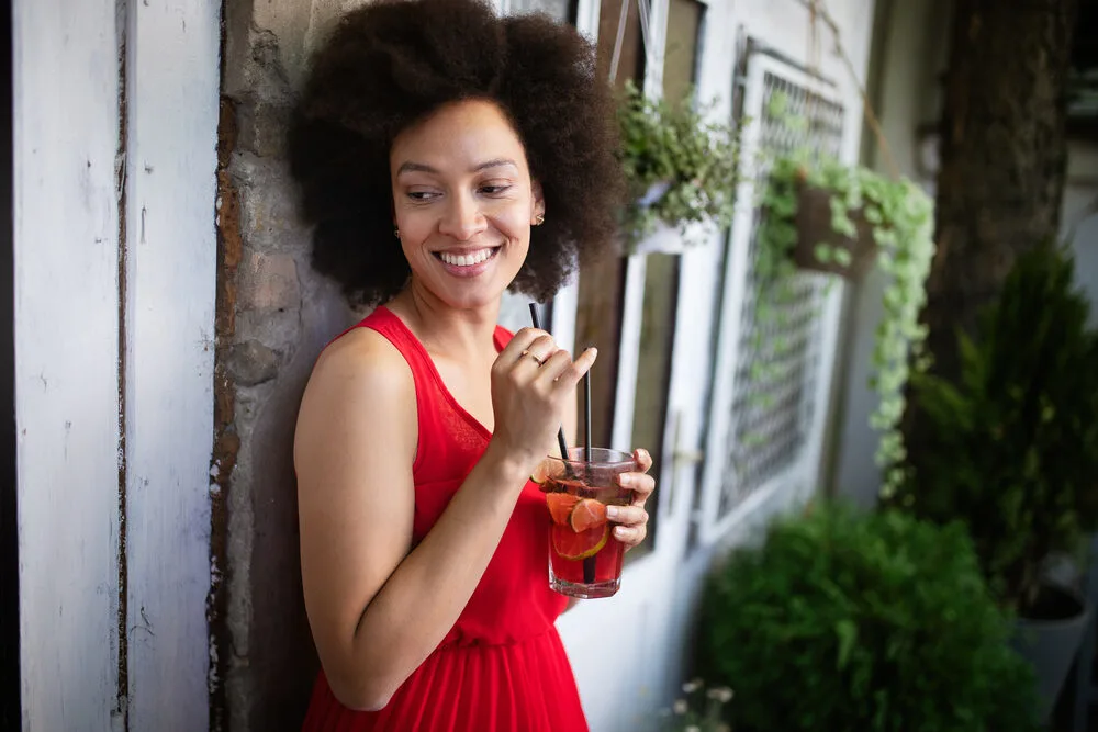 Beautiful black woman with curly dense hair wearing a wash n go hairdo.