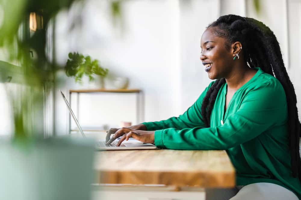 Black lady with dreads thinning at root and scalp edges reading about hair health and hair products that prevent scalp infections.