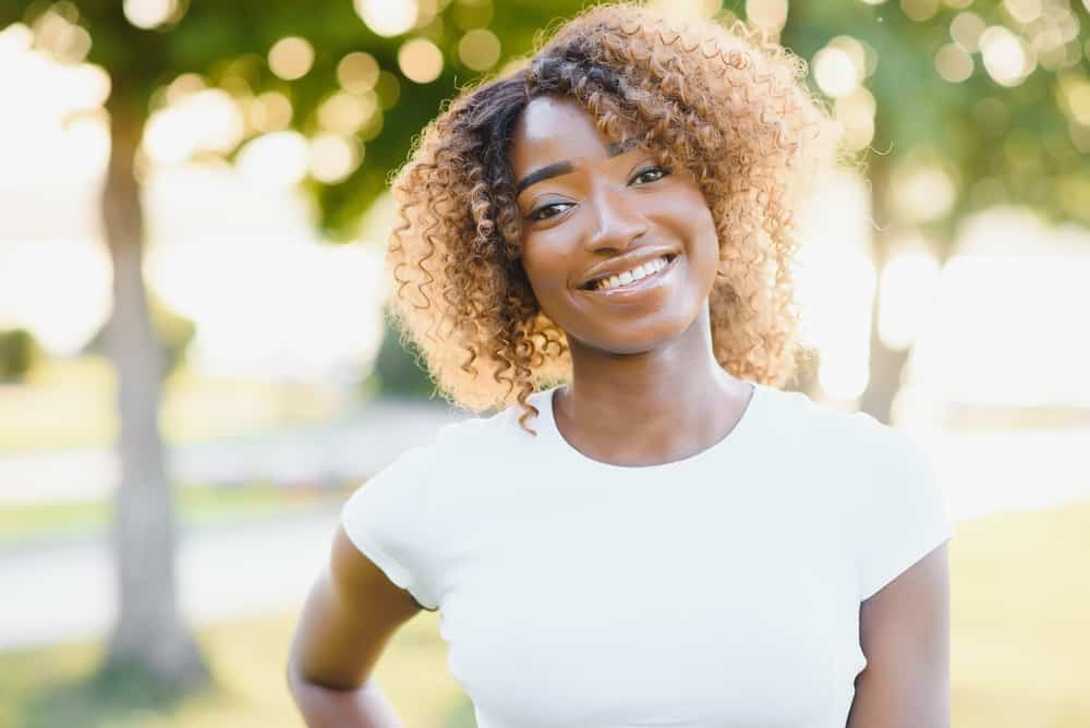 A young African American woman with high porosity hair caused by overusing box dyes.